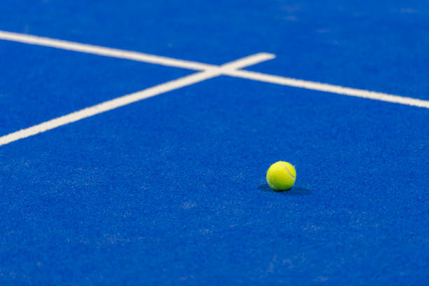 yellow tennis ball in court on blue turf. horizontal sport poster, greeting cards, headers, website - the paddle racket imagens e fotografias de stock
