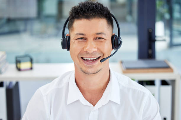 employé crm, portrait et service à la clientèle asiatique heureux de travailler en télémarketing au bureau. soutien, aide et homme agent, consultant ou travailleur souriant lors d’un appel vidéo en ligne à l’aide d’un casque - asking on the phone call center customer service representative photos et images de collection