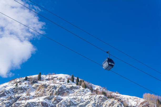 kolejka linowa dla narciarzy na tle błękitnego nieba i ośnieżonych stoków górskich, widok z dołu do góry - alatau zdjęcia i obrazy z banku zdjęć