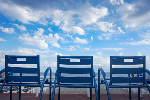 Iconic blue chairs on Promenade des Anglais in Nice, France.