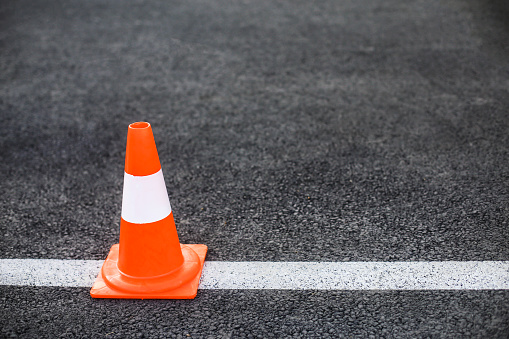 Driving obstacle course - asphalt, line and a traffic cone.