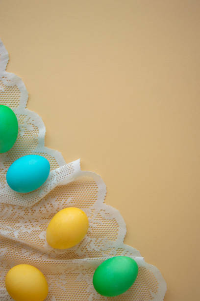 vertical photo of painted Easter eggs on lace background. Easter background or postcard. stock photo