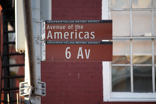 6th Av of the Americas brown traffic sign in New York