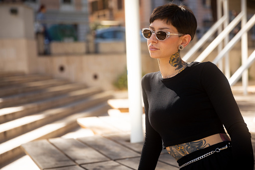 Beautiful woman with short hair portrait outdoor in the city wearing sunglasses
Copyspace on left