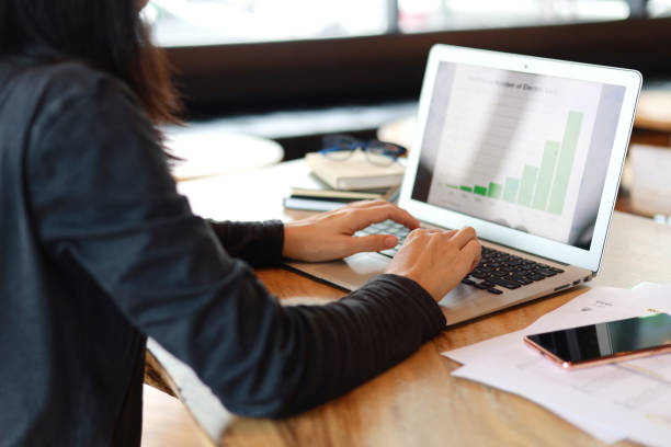 istock Young Asian woman looking at financial plan while working on laptop in office 1478115808
