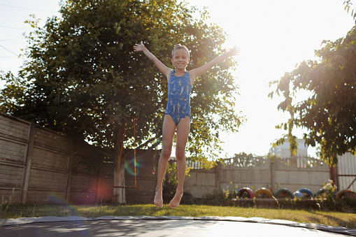 Beautiful siblings enjoying summer days. Fun on the trampoline.