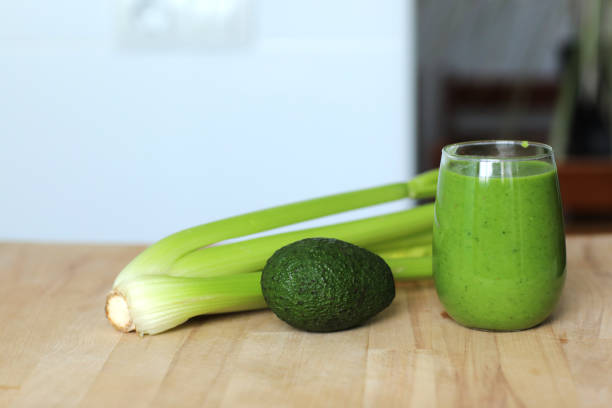 dieta wegańska i odżywianie, zdrowy detoks, wegetariańskie koncepcje napojów. szklanka z organicznym zielonym selerem smoothie, awokado na drewnianym stole. koncepcja zdrowego stylu życia - chlorofil zdjęcia i obrazy z banku zdjęć