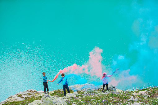 Children having fun with flare stack at mountain lake
