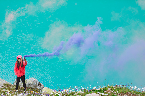 Girl having fun with flare stack at mountain lake