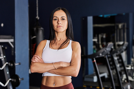 Fitness, serious and portrait of woman in gym for training, strong and sports workout. Confident, exercise and pride with female athlete in health club for coaching, personal trainer and cardio