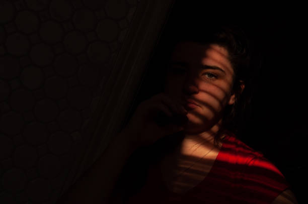 istock Venetian blinds create lines on a woman's face from the sunlight 1478122808