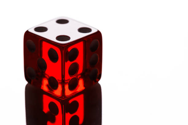 Close up photograph of two red acrylic dice on a reflecting red acrylic board.