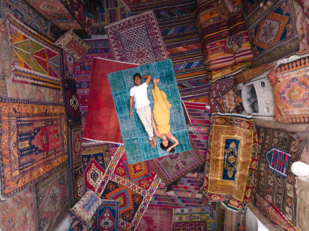 drone view of couple lying on carpet and surrounded by carpets - magical place imagens e fotografias de stock