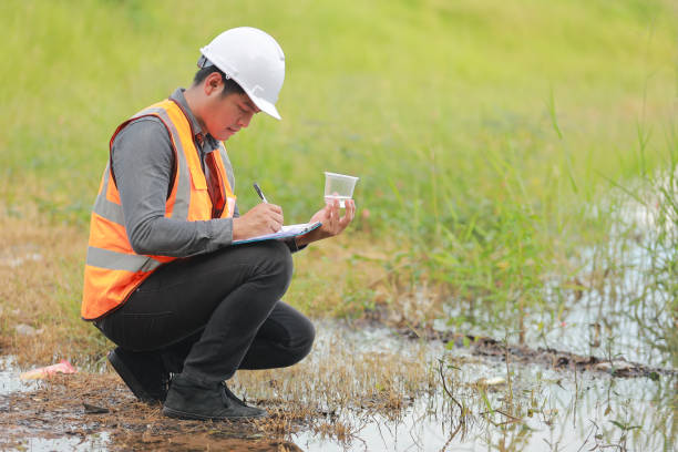 Environmental engineers work at water source to check for contaminants  in water sources and analysing water test results for reuse.World environment day concept.