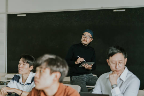 istock Asian design professor watching and listening to his student presentation work. 1478128446