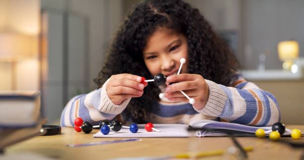 istock Girl, science with child building molecular structure, learn chemistry or physics, student focus and education. Notebook, homework and study at desk with ball and stick model, creative and scientific 1478130170