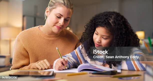 Woman Teaching Child Writing And Learning For Home Assessment Test And Memory Development At Night Personal Tutor Mother Or Family Support Helping And Creative Biracial Kid Or Student Education Stock Photo - Download Image Now