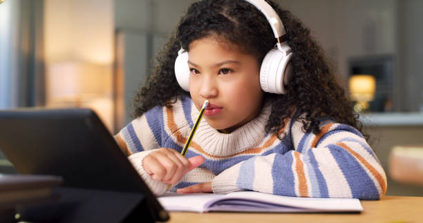 istock Headphones, tablet and child thinking in online class, elearning education and global assessment test at home. Night webinar, translation service and thoughtful, biracial kid listening to audio app 1478130262