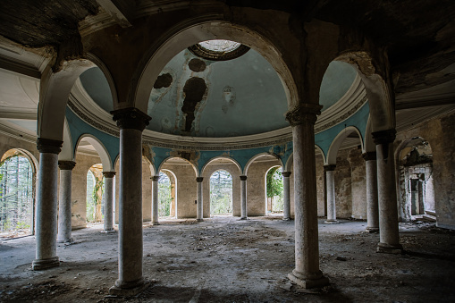 Round hall with colonnade in old abandoned palace.
