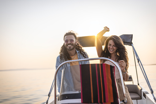 Photo of a smiling couple taking a boat ride on the sea