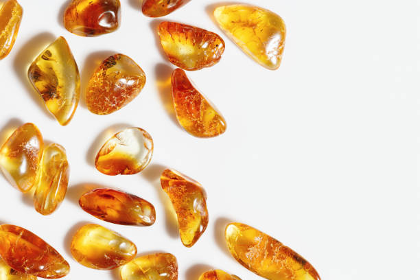 Amber stones on white background, transparent stone yellow beige gradient color. Natural gemstone mineral material, healing crystal. Top view Amber textured fon. Nature gems, frame copy space. Amber stones on white background, transparent stone yellow beige gradient color. Natural gemstone mineral material, healing crystal. Top view Amber textured fon. Nature gems, frame with copy space. amber stock pictures, royalty-free photos & images