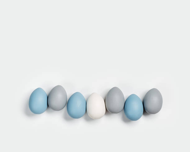 istock Dyed Easter eggs pastel colors blue, gray in row on white background. Happy Easter holiday, celebration food concept, chicken egg monochrome color. Top view table 1478133971