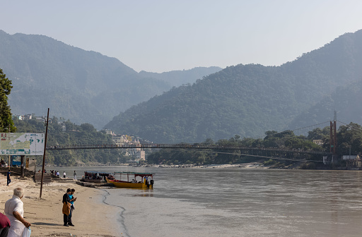 Rishikesh, Uttarakhand, India - October 2022: Scenic view of rishikesh with river ganges, cable bridge and boat.