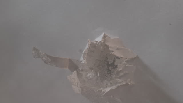 SLO MO LD Bullet making a hole into a drywall panel