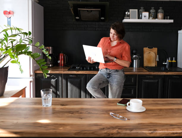 istock Woman work with laptop at home at kitchen background. Freelancer at home office concept. 1478139742