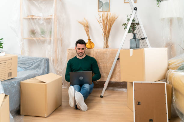 istock Young man working on laptop in living room 1478140432