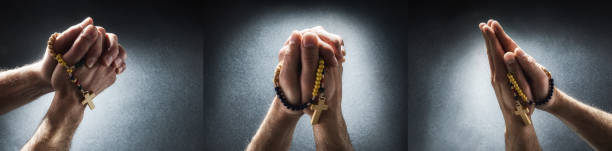 Praying man hands with hands with palms together isolated dark