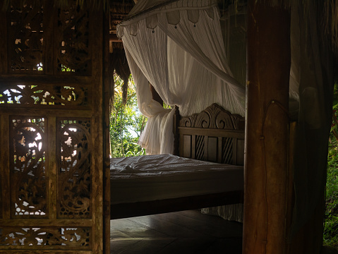 Big bed with mosquito net in a jungle hut
