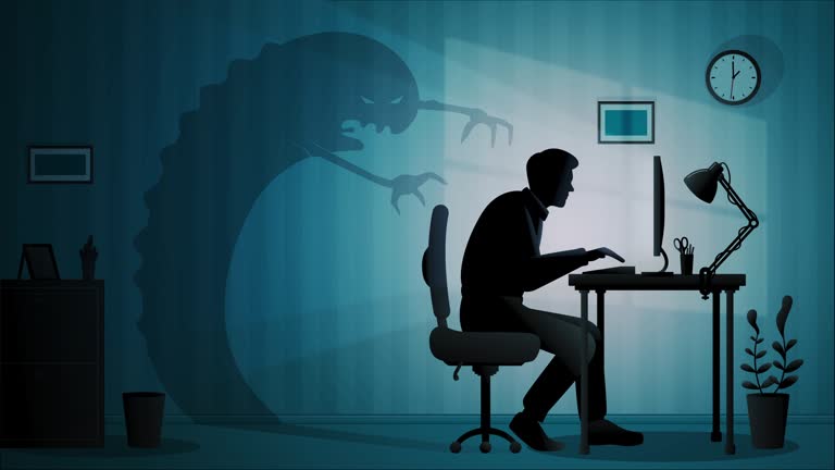 Exhausted man works late night at the office and his shadow becomes monster