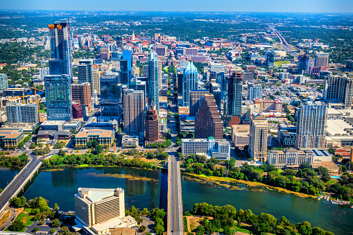 Solar Panel Community in Austin Texas a sustainable city fighting climate change with solar energy rooftop array on building surrounded by downtown skyline cityscape aerial drone view with green landscape