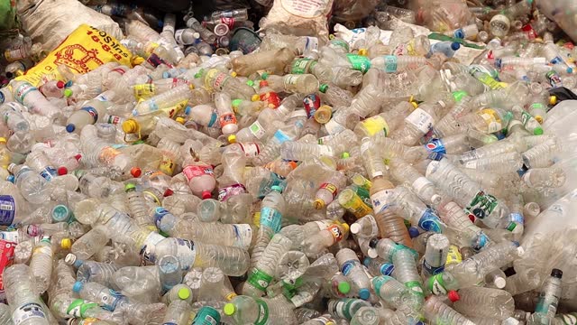 Lots of plastic and glass bottles waste in sorting plant