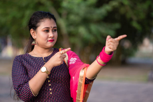 Mid adult pretty lady of Indian ethnicity wearing salwar-kameez exercising in an open gym in the park at night portrait.