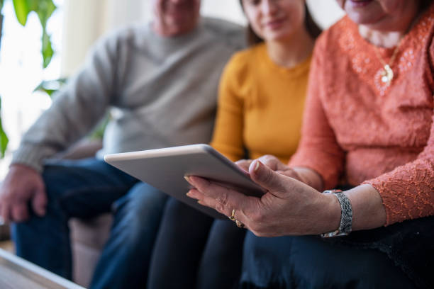 istock Granddaighter teaching her grandparents how to use digital tablet. 1478157920