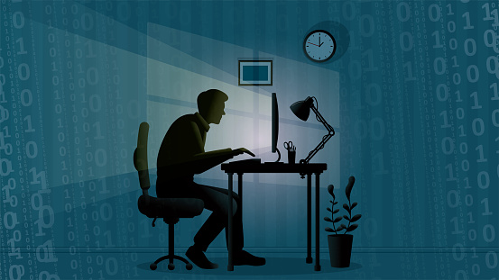 A man works alone at the office late night and writing binary codes in the dark on a blue background.