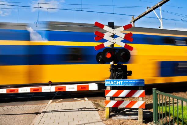 high speed train passing a railway crossing - railroad crossing railway signal gate nobody imagens e fotografias de stock