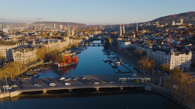 aerial drone footage of the Zurich old town along the Limmat river with landmarks such as the Grossmunster cathedral and the lake bridge in Switzerland largest city.