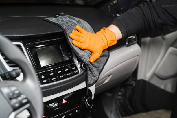 istock Worker cleans cars using microfiber cloth to dry the dashboard during the process of hand-drying the interior of the car in detailing service. 1478171809