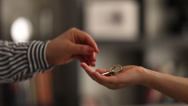 Close up focus on keys, smiling woman Real Estate Agent selling apartment