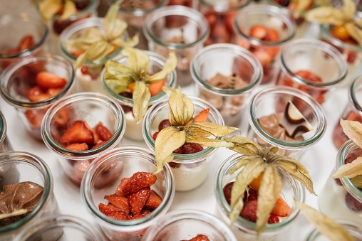 A still-life image of mason jars filled with a variety of fresh fruits and vegetables