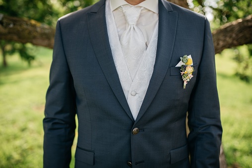 A smartly dressed person at wedding wearing a navy blue suit and a coordinating bow tie