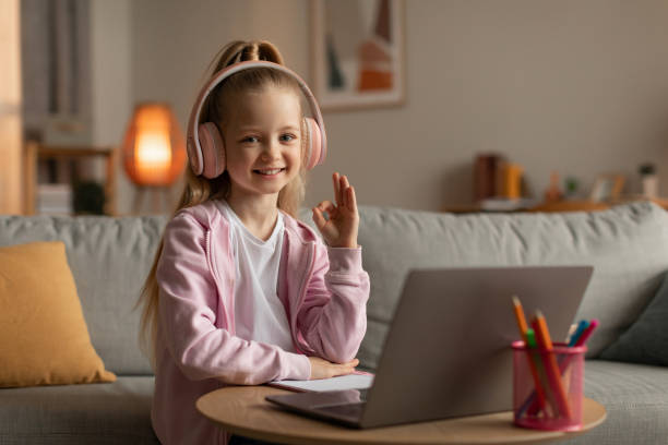 istock Little Girl Using Laptop Gesturing Okay Learning Online At Home 1478183340