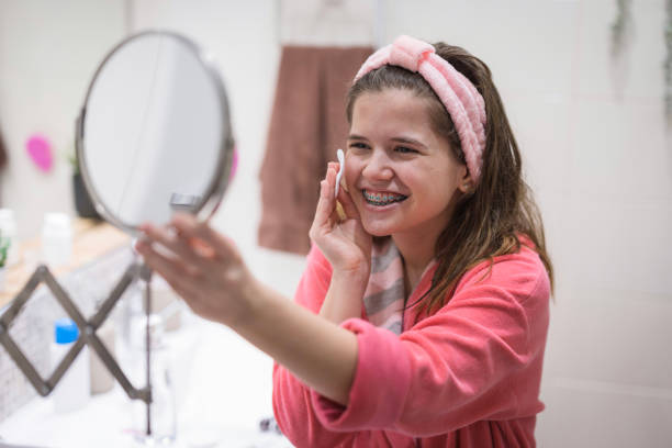 istock Teenage girl laughing when using cotton pads with moisturizer 1478186074