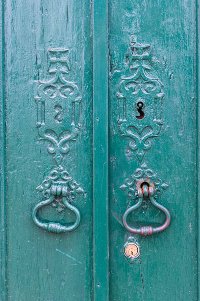 istock Metal pulls on an old green painted door. 1478186677