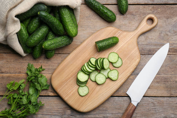 istock Fresh ripe cucumbers and parsley on wooden table, flat lay 1478192072
