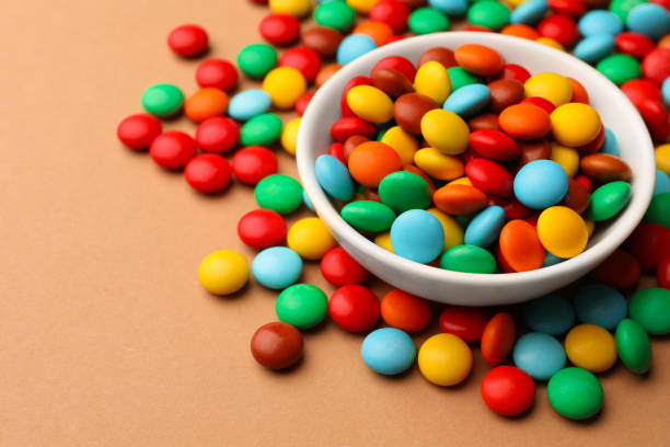 istock Tasty colorful candies on light brown background, closeup. Space for text 1478193115