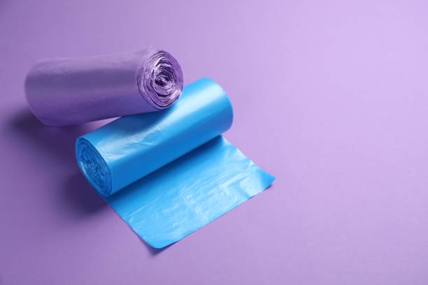 istock Rolls of different color garbage bags on violet background. Space for text 1478198435